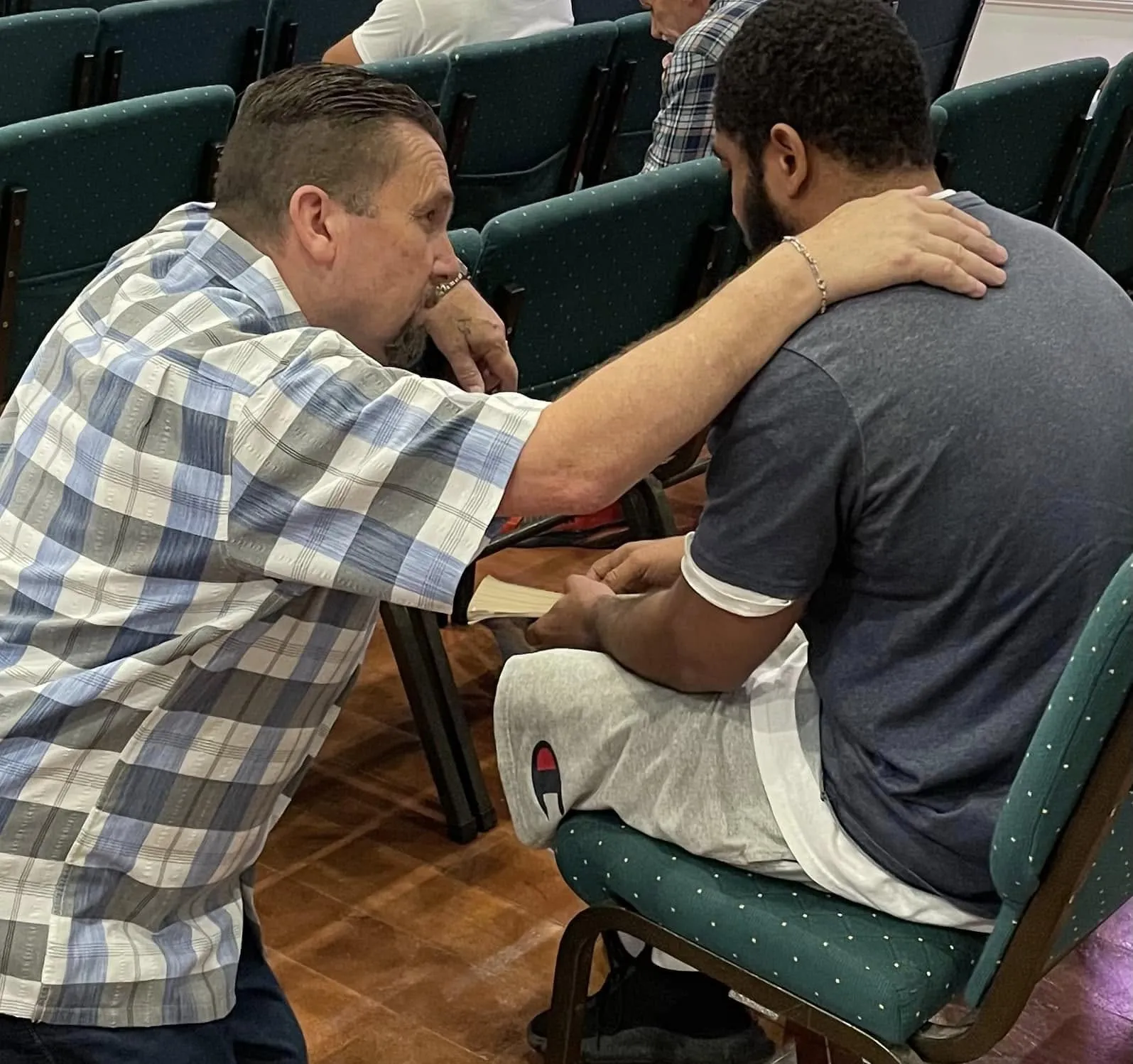 Jeff praying one-on-one with a young man at the altar