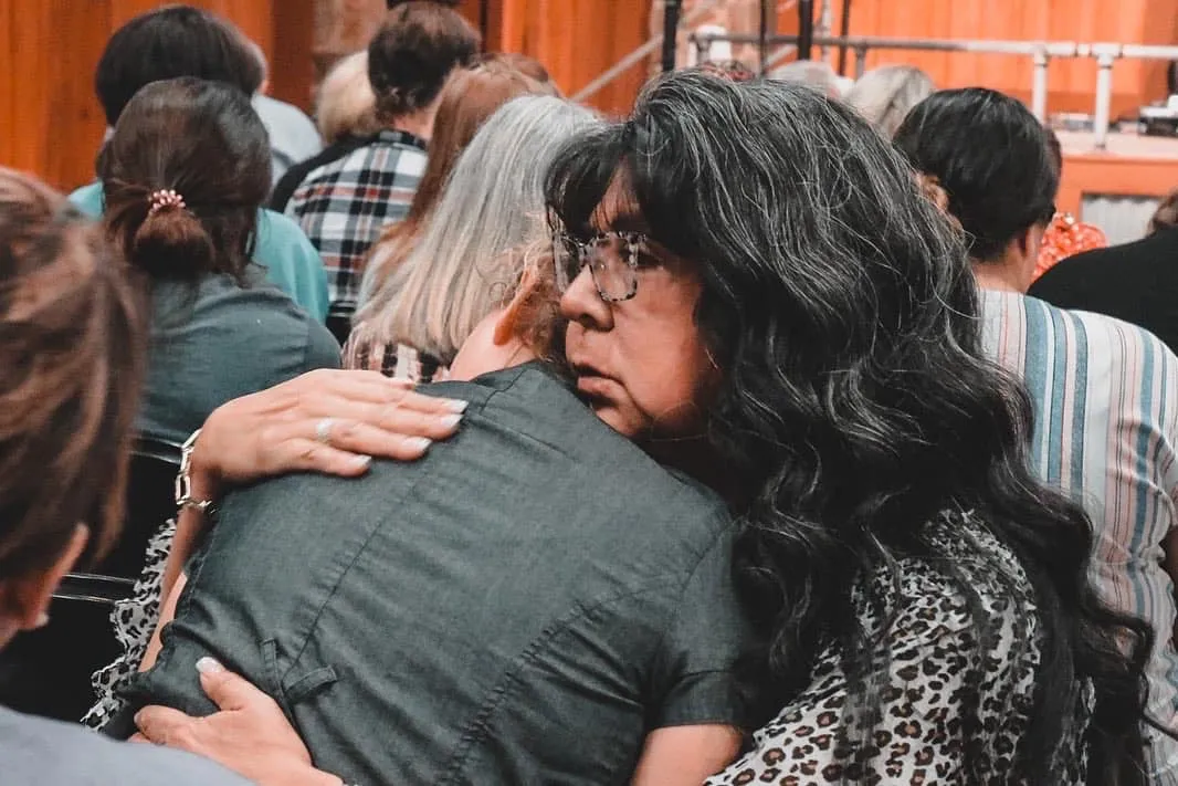 Connie embracing a woman during ministry